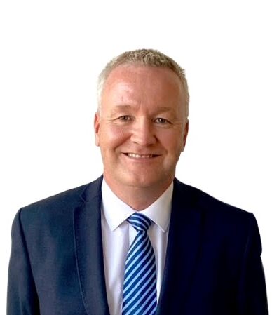 Gerry Bann smiling in a suit